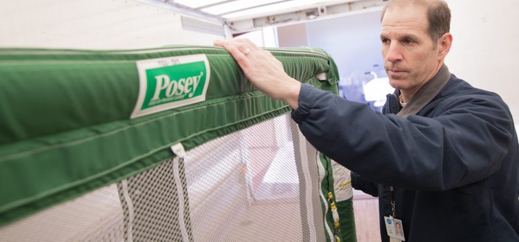 Agiliti team member pushes a Posey enclosure bed into the back of a delivery truck