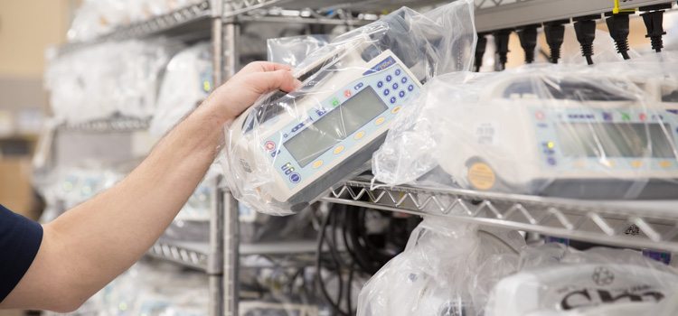 Close up of a hand pulling a Medfusion 3500 off a patient-ready shelf