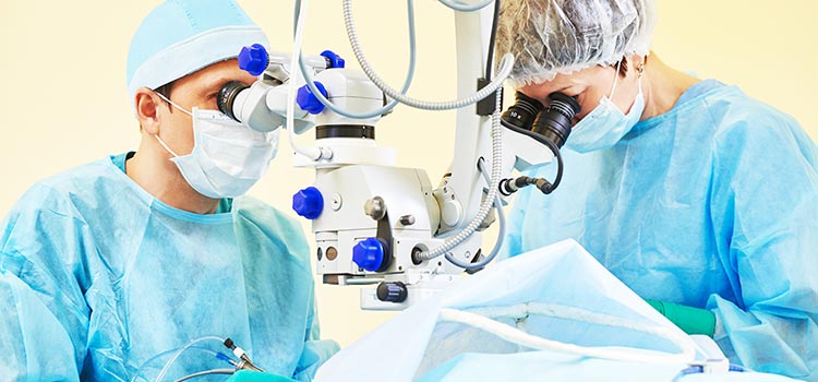 Two surgeons using magnifiers during surgical laser procedure