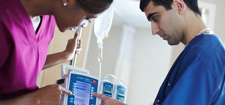 Agiliti team member in-services an infusion pump with a nurse