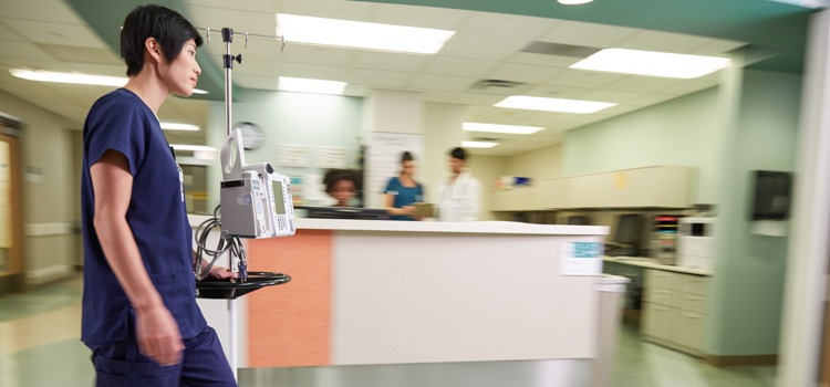 An Agiliti team member walks past a nurse station for timely delivery of an infusion pump