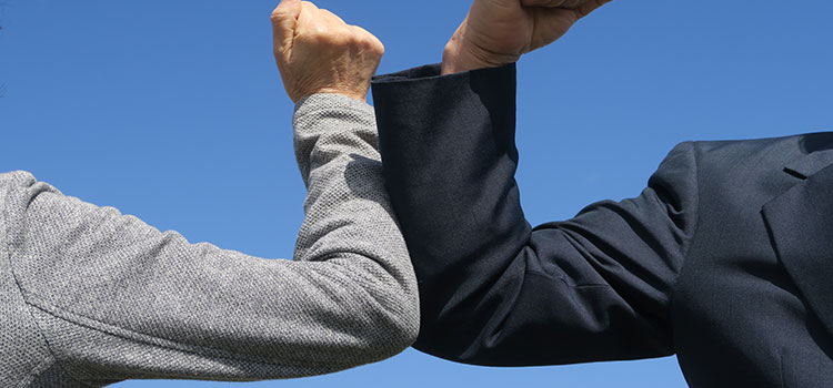 Two business professionals elbow bumping - Vendor's Standard Terms and Conditions