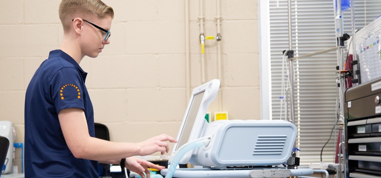 Biomedical technician providing supplemental service on a ventilator