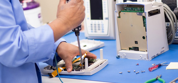 Healthcare technology management expert repairing infusion pump