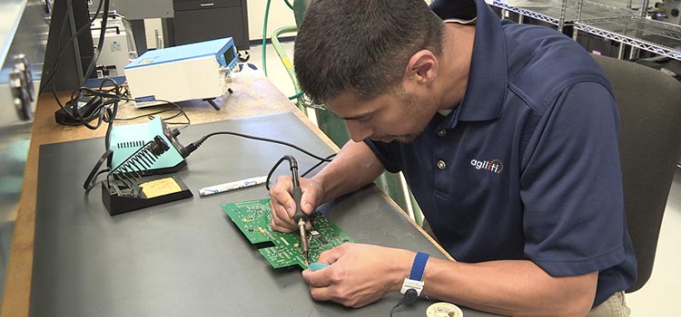 Biomedical tech repairing a circuit board for a medical device