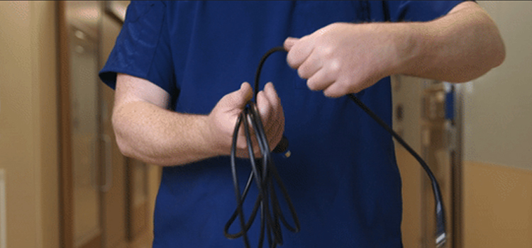 SPD technician properly wrapping a surgical video camera cord