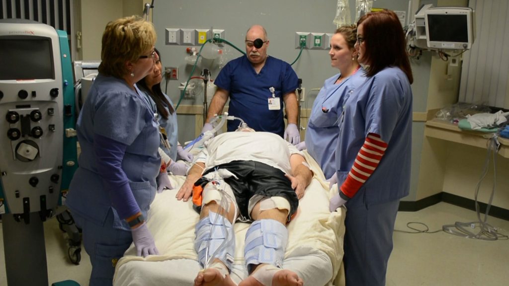 Patient in supine position with nurses preparing to manually reposition